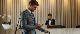 A man with luggage uses a mobile hotel app